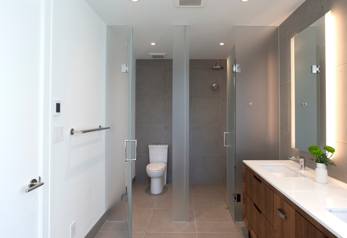 Luxury bathroom in Toronto home with double vanity and doors open to shower