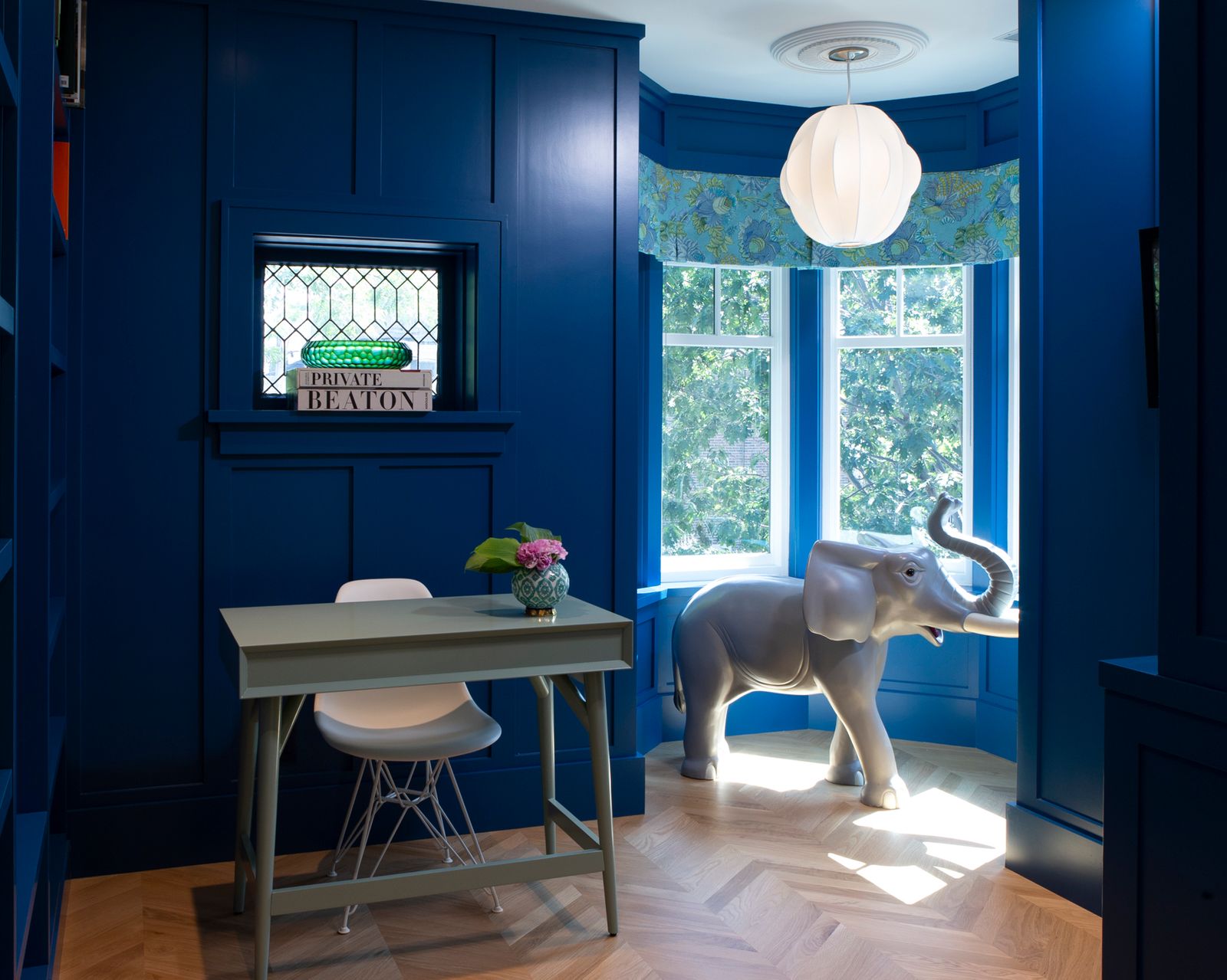 Upstairs library with Benjamin Moore blue painted walls and chevron pattern flooring with desk and chair