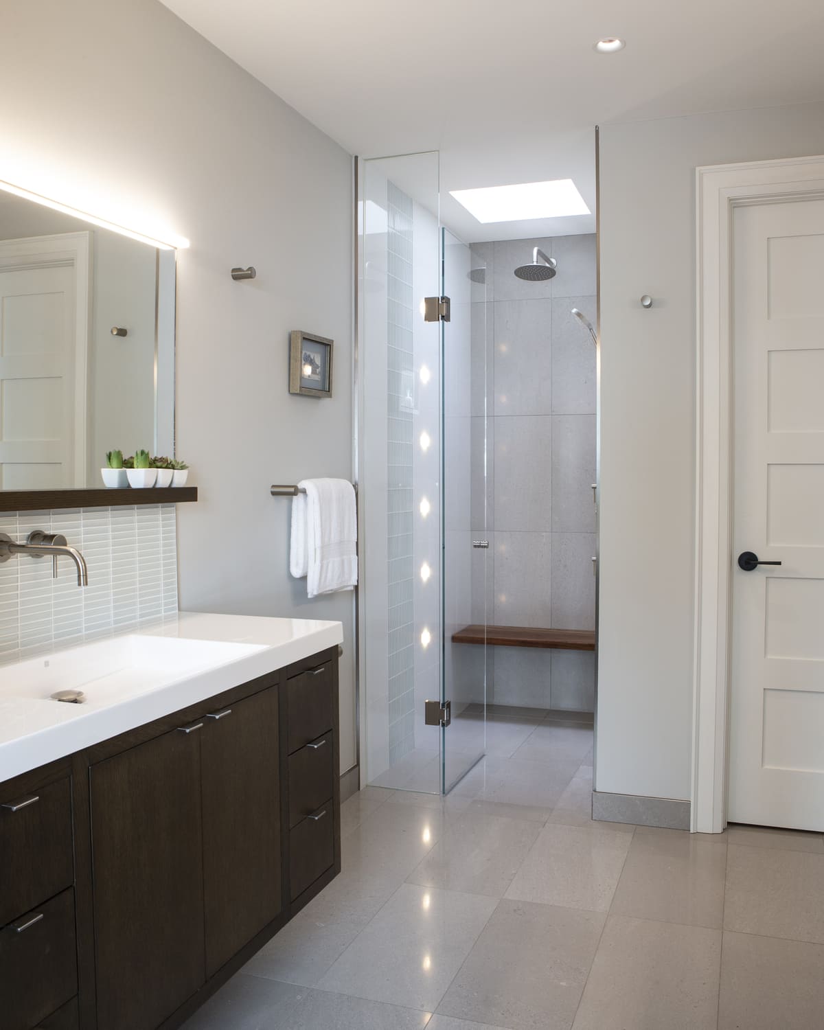 Walk-in shower with built-in bench and large format tilling in Toronto home renovation