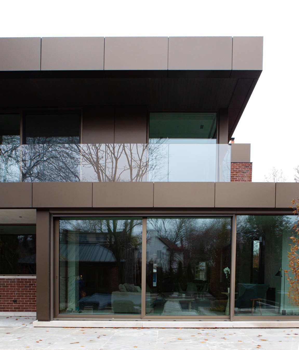 Home addition exterior with ACM cladding and glass paneling on upper deck by SevernWoods