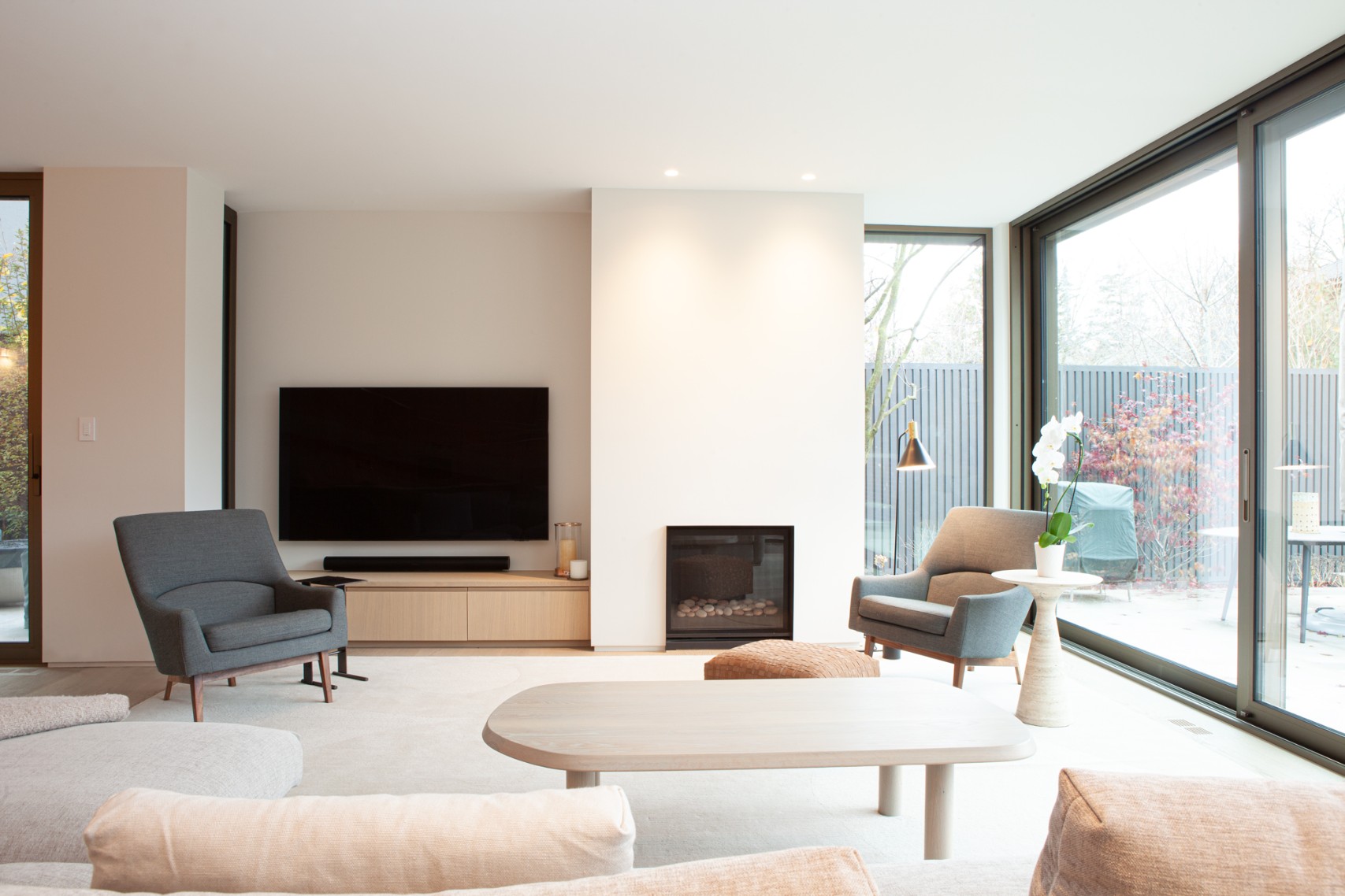 Luxury living room area with gas fireplace and natural light coming in from windows in Toronto addition and renovation