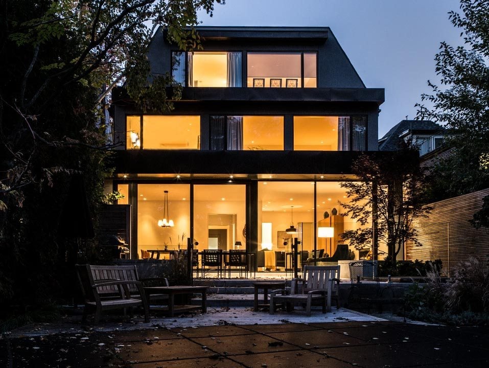 modern contemporary exterior custom home in moore park toronto at dusk with lots of windows and indoor lights on