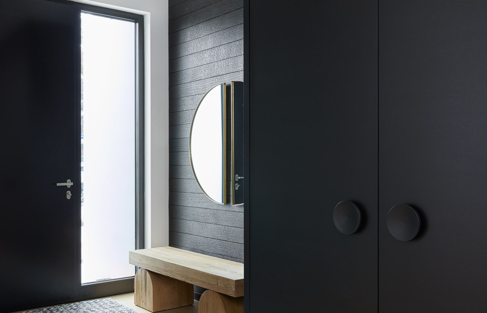 Yakisugi wood in entryway of modern home with circular wooden bench