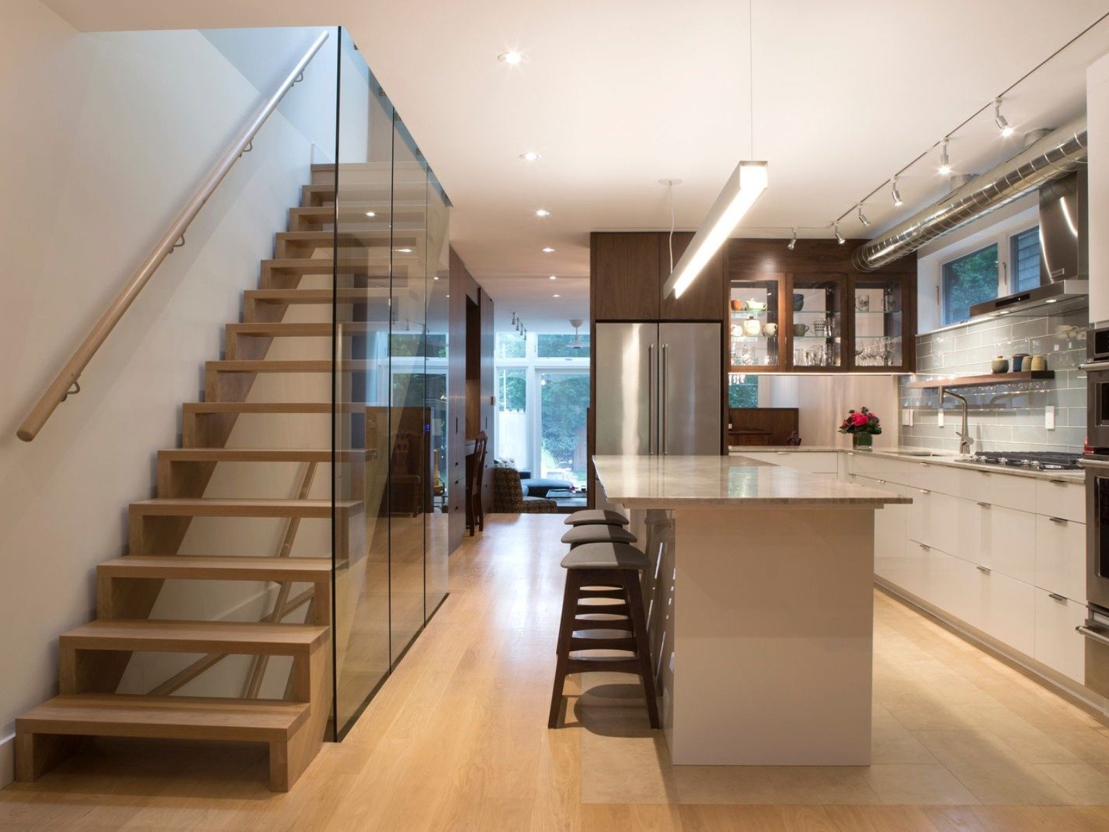 kitchen with island and barstools and floating staircase